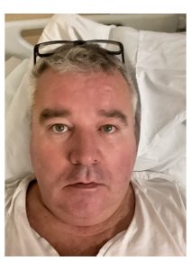 Headshot of Chris Ward in bed.