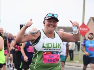 'Renegade Toni' mid race with arms raised in a thumbs up gesture at the camera.