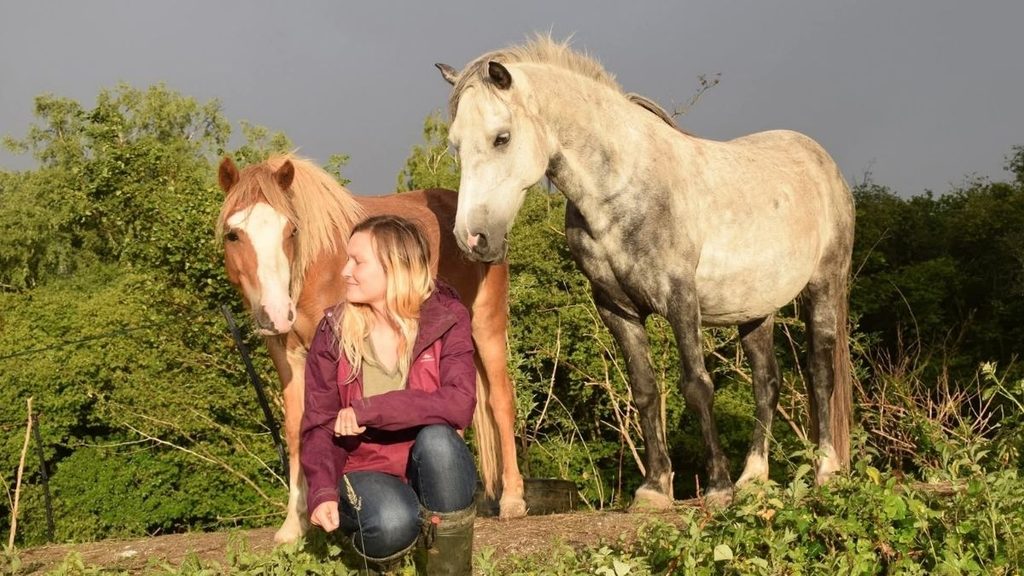 Maja with two horses in the countryside.